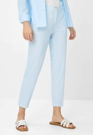Helle blaue karierten Hosen aus einem glatten Stoff, die ein figurbetontes Design, einen vorderen Knopfverschluss und ein verjüngtes Bein aufweisen. Kombiniert mit weißen Sandalen.