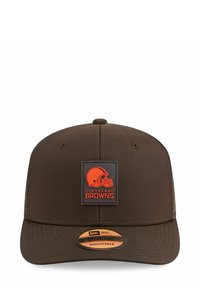 Braune Baseballmütze mit strukturiertem Design, auf der Vorderseite mit einem orangefarbenen Cleveland Browns Logo-Patch und einem verstellbaren Riemen auf der Rückseite.