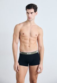 Schwarze Boxer Shorts mit elastischem Bund und "BOSS"-Logo. Glattes Material mit figurnaher Passform, Oberschenkellänge und minimalen Nähten.