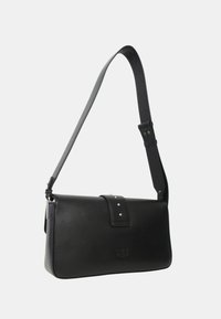 Borsa a spalla in pelle nera con forma piatta, tracolla regolabile e chiusura a bottone, con dettagli in borchie argentate sulla patta.
