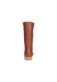 Bota de cuero marrón hasta la rodilla con una superficie texturizada. Presenta una suela de goma plana y un pequeño detalle de botón en la parte superior.