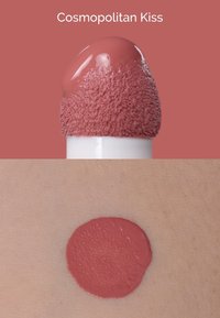 Producto para labios en un tono rosa suave y apagado. Presenta una punta aplicadora esmerilada y una textura cremosa y suave, mostrada en la piel en una muestra circular.
