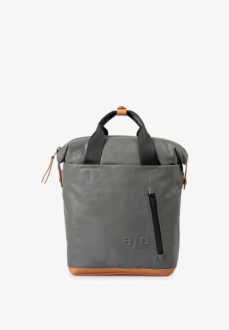 Grijze leren rugzak met bruine accenten, bovenhandvaten en verstelbare schouderbanden. Bevat een geopperde voorkantzak en een minimalistisch ontwerp.