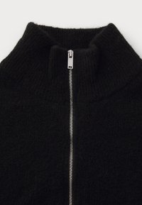Black knitted sweater with a silver metal zipper and a high collar, shown flat on a white background.