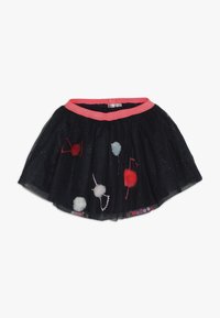 Czarna spódnica z tiulu z różowym, błyszczącym paskiem w talii, ozdobiona czerwonymi i białymi pomponami oraz haftowanymi wzorami kokardek.