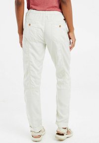 Pantaloni cargo beige chiaro con vestibilità comoda, vita elastica, due tasche posteriori e orli arrotolati. Realizzati in un tessuto resistente.