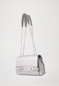 Bolso de hombro de piel sintética gris con herrajes dorados, que presenta una solapa plegable, doble hebilla y una correa de cadena. Textura suave, diseño compacto.
