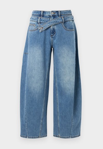 Ανοιχτό μπλε τζιν παντελόνι με φαρδιά πόδια από τζιν ύφασμα, με μοναδική ζώνη που τυλίγεται γύρω, χαρακτηριστικές ξεθωριασμένες περιοχές και ορατές ραφές.