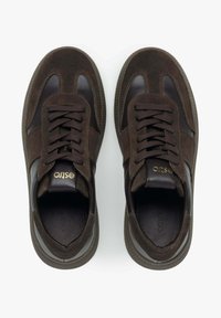 Brązowe zamszowe sneakersy z skórzanymi akcentami, okrągłym noskiem, płaskimi sznurówkami, złotym logo na języku i teksturowaną gumową podeszwą.