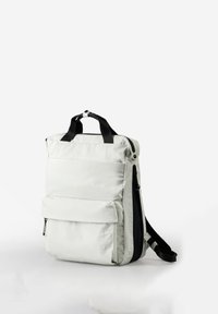 White rectangular backpack with front zipper pocket, black top handles, and adjustable shoulder straps on a white background.