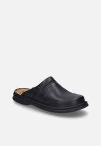 Black leather clogs with a smooth texture, low heel, round toe, and stitched detailing along the edges. Minimalist design without fasteners.