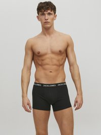 Schwarze Boxershorts mit einem dicken elastischen Bund, auf dem der Text "JACK & JONES" in weiß zu sehen ist, getragen von einem nackten männlichen Model.
