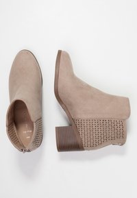 Ruske mokasine do gležnja od suede s geometrijskim izrezom i nanešenim potplatom. Imaju zatvaranje na patentni zatvarač i glatku unutrašnju oblogu.
