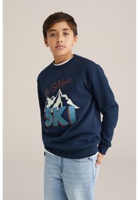 Tmavě modrá mikina s grafikou hor, nápisy "Les Alpes" a "SKI" v červené a modrozelené barvě. Kulatý výstřih, žebrované manžety a pas. Volný střih.