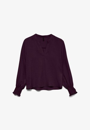 Lange mouwen bordeaux paarse blouse van textuurstof, met V-hals en smockmanchetten met ruches op een witte achtergrond.