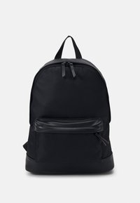 Černý batoh s hladkým textilním povrchem, zaobleným tvarem, dvojitým zipem, přední kapsou a minimalistickým designem.