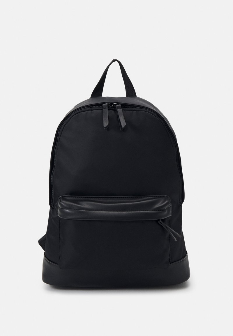 Černý batoh s hladkým textilním povrchem, zaobleným tvarem, dvojitým zipem, přední kapsou a minimalistickým designem.