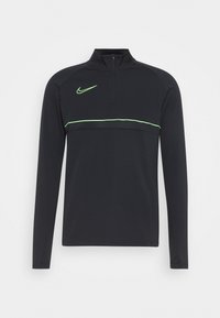 Musta pitkähihaisen puolivetoketjullinen pusero, joka on valmistettu sileästä kankaasta. Rinnassa on heijastava neonvihreä raita ja Nike-logo.