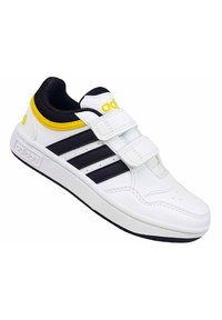 Zapatilla blanca con rayas negras y acentos amarillos. Cuenta con un upper sintético suave, un collar acolchado y dos correas de Velcro.