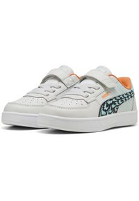 Baskets blanches en cuir avec fermeture à lacets et Velcro, présentant un accent noir et teal à motifs et un détail de talon orange. Semelle texturée.