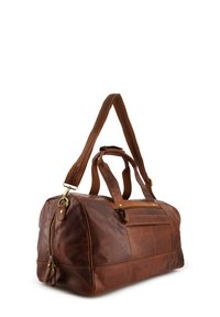 Brązowa torba podróżna ze skóry z podwójnymi uchwytami, regulowanym paskiem na ramię i zamykaną kieszenią. Gładka faktura z niewielkimi metalowymi elementami.