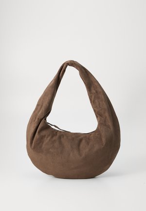 Brun ruskinds hobo bag med en rund form og et langt, buet håndtag. Teksturen virker blød, med et sømløst design uden synligt hardware.