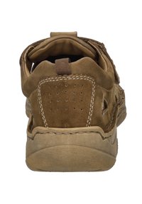 Brązowy zamszowy but o zaokrąglonym kształcie, z widocznymi detalami stębnowania i teksturowaną podeszwą. Zawiera pętelkę na pięcie oraz małe perforacje.