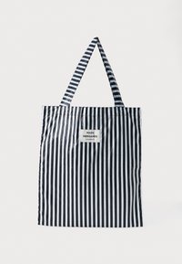 Svart og hvit stripete totebag i rektangulær form, laget av glanset materiale. Har to stripete håndtak og en merkelapp i midten.