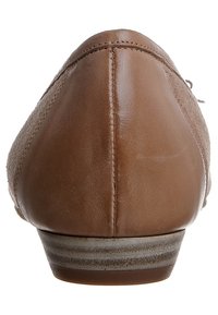 Scarpa in pelle marrone con superficie liscia e punta arrotondata. Tacco basso con suola texturizzata. I dettagli delle cuciture sono visibili lungo il retro.