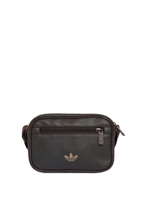 Lille rektangulær mørkebrun lædertaske med lynlåslomme foran og Adidas-logo i guld i midten.