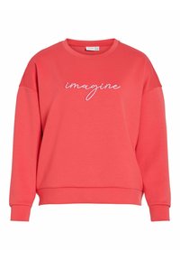 Bluza w kolorze koralowym wykonana z miękkiej tkaniny, z okrągłym dekoltem i haftowanym białym napisem "imagine" na piersi.