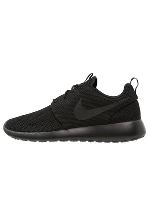 Chaussure de course Nike noire en tissu mesh, avec lacets et semelle épaisse, vue de profil sur fond blanc.