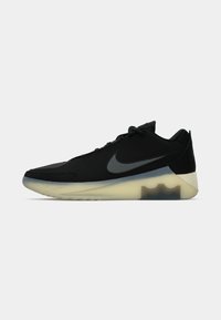 Čierna atletická obuv s textúrovaným zvrškom, pričom obsahuje šedé logo Nike, priehľadnú medzipodrážku a charakteristický geometrický dizajn päty.