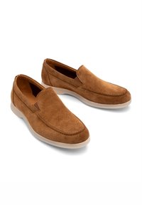 Brązowe zamszowe buty wsuwane z zaokrąglonym noskiem, kontrastującym przeszyciem i białą gumową podeszwą. Gładka tekstura, minimalistyczny design.