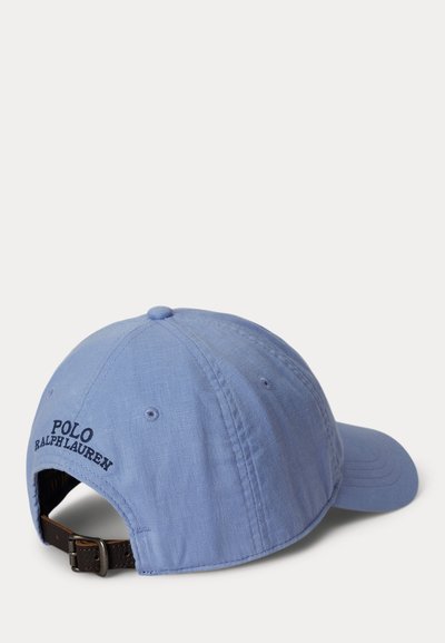 Ανοιχτό μπλε καπέλο μπέιζμπολ Polo Ralph Lauren με ρυθμιζόμενο καφέ δερμάτινο λουράκι και μεταλλικό πόμολο, εμφανιζόμενο από την πίσω δεξιά πλευρά.