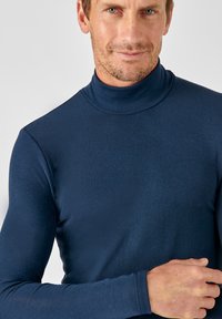 Navyblauwe, langmouwen coltrui van een gladde, stretchstof. Aansluitend ontwerp met een lage halslijn en minimale stikseldetails.