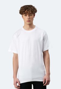 Weißes Baumwoll-T-Shirt mit kurzen Ärmeln, Rundhalsausschnitt und lockerer Passform, auf einem neutralen Hintergrund präsentiert. Keine auffälligen Muster oder Akzente.