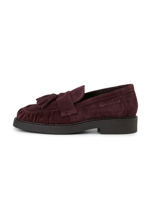 Bordeauxfarbener Wildleder-Slipper mit Quasten-Detail vorne, niedriger schwarzer Gummisohle und leichtem Absatz, von der Seite auf weißem Hintergrund gezeigt.