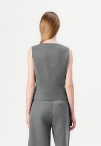 Top grigio senza maniche con scollatura quadrata, vestibilità sagomata e orlo leggermente svasato; realizzato in tessuto morbido e strutturato.