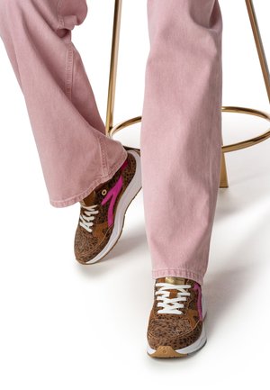 Braune Sneaker mit Leopardenmuster, weißen Schnürsenkeln, pinken Akzenten und dicker weißer Sohle, kombiniert mit hellroten Jeans.