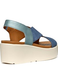Sandali wedge in pelle blu e azzurri con design incrociato, dotati di una soletta color beige e una spessa suola piattaforma bianca.