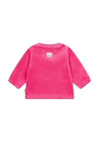 Camisa de terciopelo rosa de manga larga con un parche de cara de oso en la parte de atrás. Mangas con puños y escote redondeado, textura suave en todo el tejido.