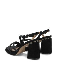 Sandalias de ante negras de tacón alto con tacones gruesos, múltiples correas delgadas y una correa de tobillo ajustable con hebilla.