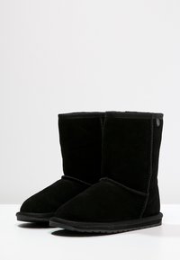 Stivaletti in suede nero con punta rotonda, dettagli cuciti, texture liscia e suola piatta in gomma. Nessun hardware o accentuazione visibile.