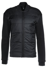 Veste noire avec un devant matelassé, col côtelé et poignets élastiques. Combinaison de tissus lisses et texturés avec une fermeture zippée.