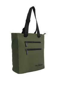 Bolso tote de nailon verde con dos bolsillos frontales con cremallera, acentos de hardware negro y correas acolchadas que presentan el nombre de la marca. Textura suave.