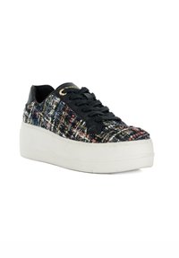 Zwarte sneaker met een meerkleurig geweven stoffen bovendeel, dikke witte platformzool, zwarte veters en gouden oogjes als accent. Textuur detail.