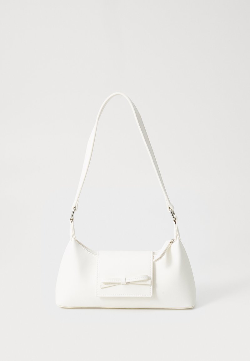 White synthetic handbag with a triangular shape, flat front flap and bow detail, adjustable strap, smooth texture, and minimalistic design.
