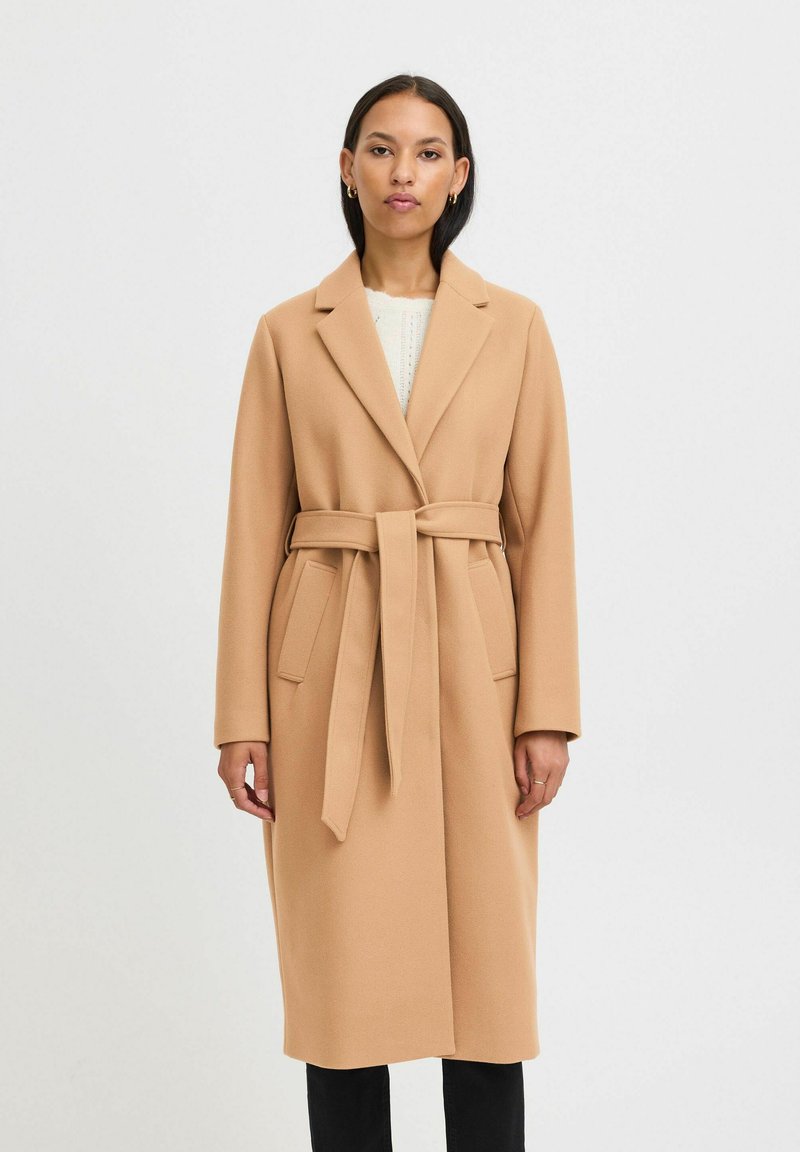 Manteau en laine mélangée couleur camel avec une taille ceinturée, des revers notched et des poches latérales, présentant une silhouette à mi-longueur et une texture lisse.