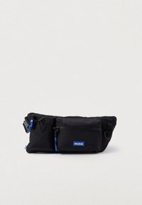 Μαύρη ζώνη μέσης από νάιλον, με μπλε φερμουάρ και διακοσμητικά στοιχεία. Σ包含ομει περιλαμβάνει μπροστινή θήκη με φερμουάρ και ρυθμιζόμενο λουρί για ασφαλή χρήση.